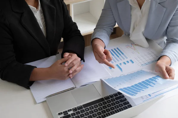 Two business leader women discussing the charts and graphs showing the results