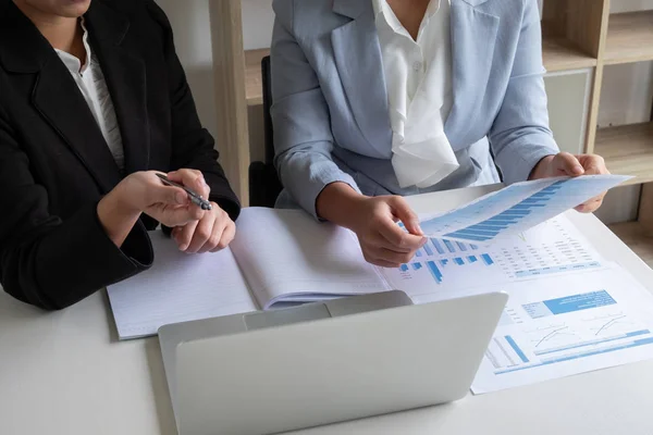 Two business leader women discussing the charts and graphs showing the results