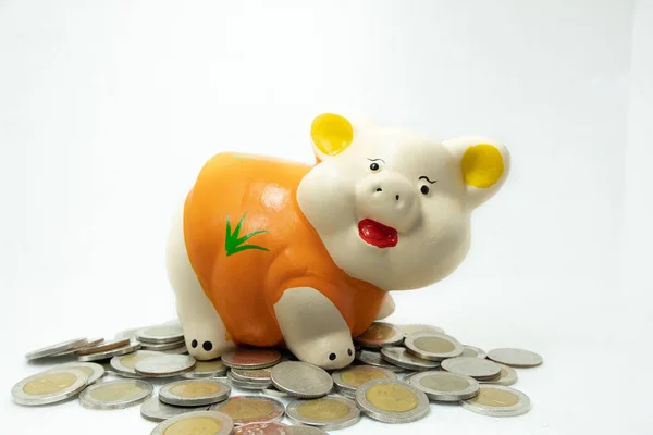 Orange piggy bank saving money with coins pile