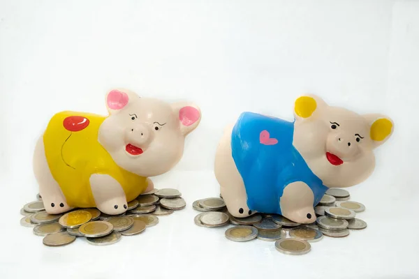 Amarelo e azul porquinho banco economizando dinheiro e moedas pilha — Fotografia de Stock