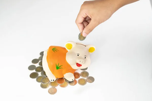 Hand putting Coin in oranje Piggy Bank geld besparen met munten — Stockfoto