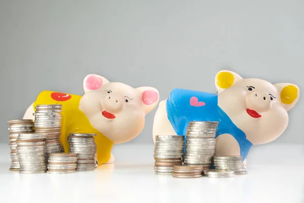 Yellow and Blue piggy bank saving money with coins pile