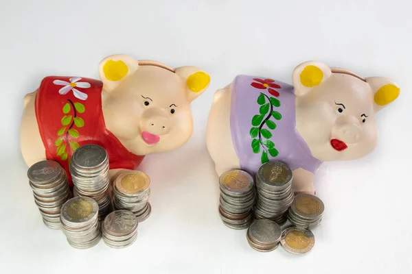 Red and Purple piggy bank saving money with coins pile