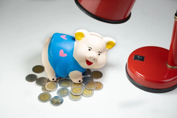 Blue piggy bank pe gramada de monede cu lampa rosie — Fotografie, imagine de stoc