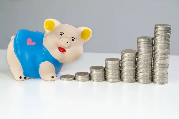 Blue piggy bank saving money with coins bar graph