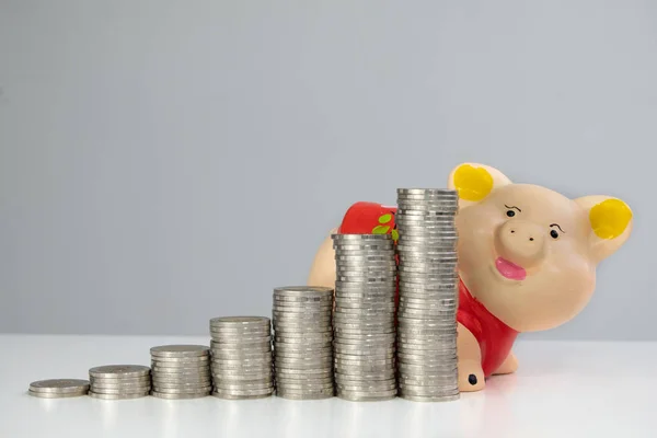 Red piggy bank saving money with coins bar graph