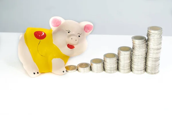 Желтая свинья копит деньги с помощью монет — стоковое фото