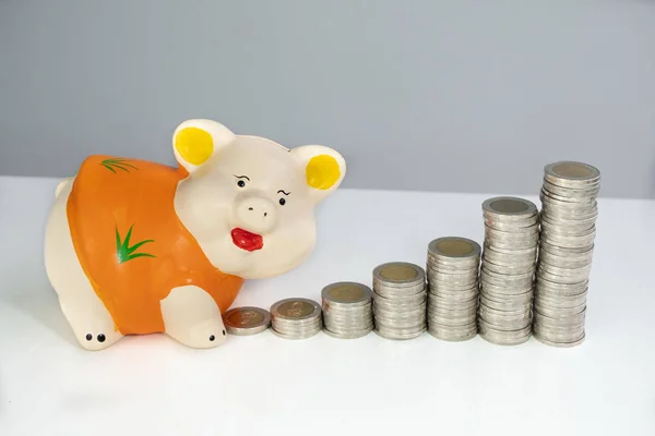 Orange piggy bank saving money with coins bar graph