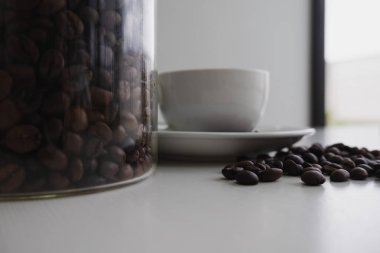 cam şişede beyaz fincan ve kahve çekirdeği