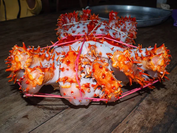 Caranguejo rei Alaska congelado pronto na mesa de madeira para cozinhar — Fotografia de Stock