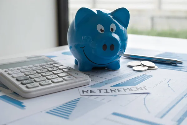 Kalem hesap makinesi ve Grafik ile Mavi kumbara, başarı ve emeklilik kavramı için tasarruf büyüyen iş hızlandırmak