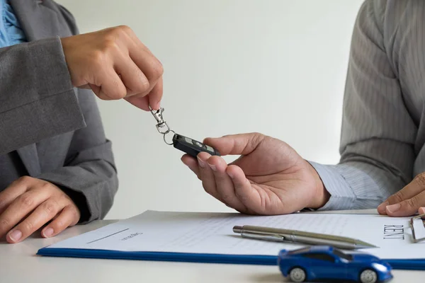 Concesionario de coches ofrece asesoramiento sobre los detalles del seguro y la información de alquiler de coches y entrega las llaves después de firmar el contrato de alquiler — Foto de Stock