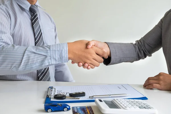 shaking hands, Car dealership provides advice about insurance details and car rental information and delivers the keys after signing the rental contract