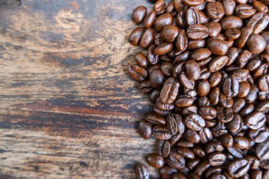 Kahve çekirdekleri kahverengi ahşap masa arka plan üzerinde