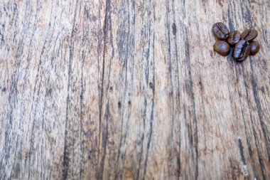 Kahve çekirdekleri kahverengi ahşap masa arka plan üzerinde