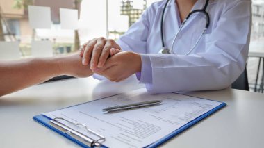 Kadın doktor, hastanın elini tutmak için dost canlısı bir el kullanır. Güvenini kazanmak ve sağlık hizmetlerine önem verdiğini göstermek için. Tıbbi kavramlar ve sağlık