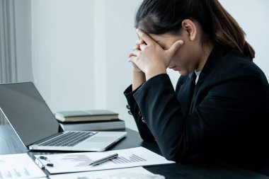 Ofis masasında oturmaktan başı ağrıyan yorgun bir iş kadını..