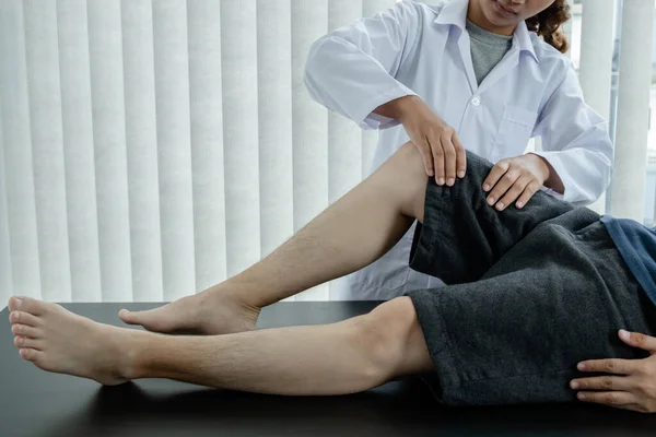 男病人向有膝痛问题的理疗师求诊和治疗 康复理疗概念 — 图库照片
