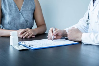 Erkek doktorlar, hasta bir doktorla görüştükten ve hastalıkla ilgili sonuçlar aldıktan sonra, tedaviyi bir reçeteyle açıklar ve tavsiye ederler..