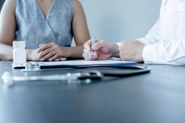 Erkek doktorlar, hasta bir doktorla görüştükten ve hastalıkla ilgili sonuçlar aldıktan sonra, tedaviyi bir reçeteyle açıklar ve tavsiye ederler..