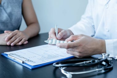 Erkek doktorlar, hasta bir doktorla görüştükten ve hastalıkla ilgili sonuçlar aldıktan sonra, tedaviyi bir reçeteyle açıklar ve tavsiye ederler..