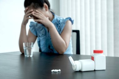 Ofis çalışanı baş ağrısını tedavi etmek ve iş yerinde dinlenmek için ilaç alıyor..