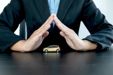 Araba, müşteriyi koruyan bir kadının eliyle kaplıdır. Arabayı alan kişinin. Kiralama ve sigorta kavramları.