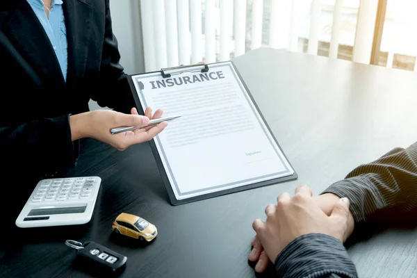 The car dealer advises the customer about insurance details and car rental information Ready delivers the keys after signing the rental contract.