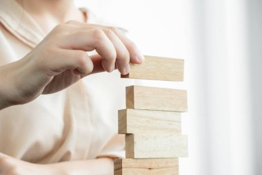 Ahşap blok oyunu oynayan iş kadınlarının elleri. Ticari büyüme ve başarı için yönetim riski ve strateji planlarını kabul et.