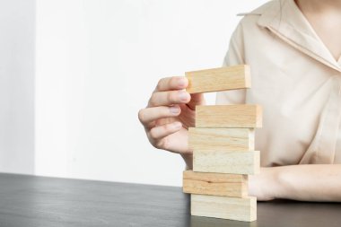 Ahşap blok oyunu oynayan iş kadınlarının elleri. Ticari büyüme ve başarı için yönetim riski ve strateji planlarını kabul et.