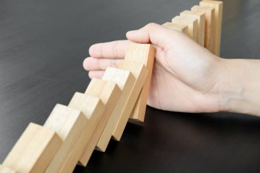 İş kadınının elleri tahta bir bloğu kumar oynayarak engelliyor. Yönetim ve strateji planını kabul et, işi başarıya kadar koru.