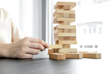 Ahşap blok oyunu oynayan iş kadınlarının elleri. Ticari büyüme ve başarı için yönetim riski ve strateji planlarını kabul et.