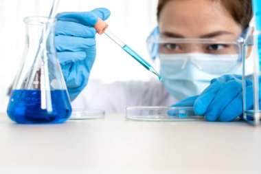 Tıp bilimcileri, bir kimya laboratuvarında virüsü analiz etmek için test camına yerleştirilmiş bir örnek yayınladılar. Bilimsel araştırma kavramları.