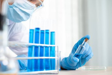Tıp bilimcileri bir kimya laboratuvarında virüsü analiz etmek için deney şişesine yerleştirilmiş bir örnek bıraktılar. Bilimsel araştırma kavramları.
