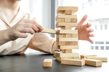 Ahşap blok oyunu oynayan iş kadınlarının elleri. Ticari büyüme ve başarı için yönetim riski ve strateji planlarını kabul et.