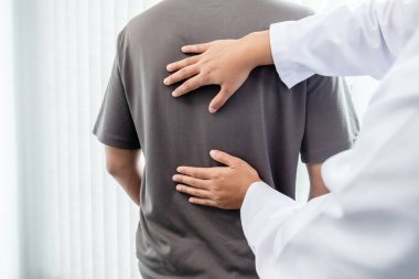 Erkek hastalar muayene ve tedavi için düşük bel ağrısı olan fizyoterapistlere danıştılar. Rehabilitasyon fizyoterapi konsepti.