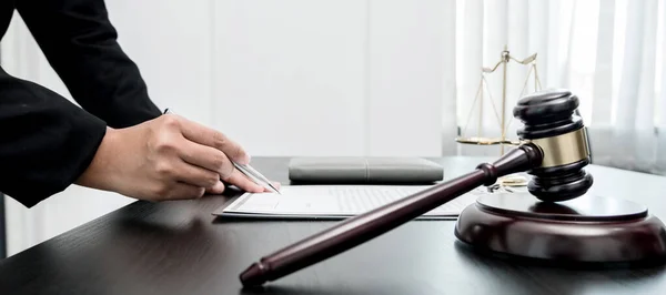 Profesyonel kadın avukatlar bir hukuk bürosunda çalışıyor. Teraziler, adalet terazileri, yargıç tokmağı ve dava belgeleri var. Hukuk ve adalet kavramları.