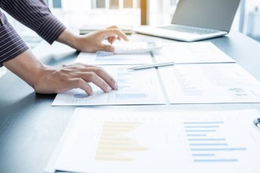 Bir erkek işadamının elleri, ofisteki bakiyeleri özetlemek amacıyla mali bir grafikte yıllık gelir ve giderleri analiz ediyor ve hesaplıyor..