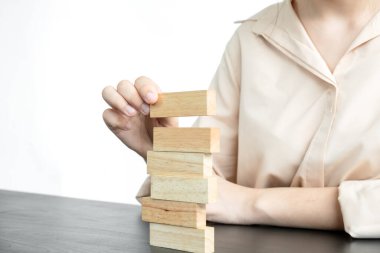 Ahşap blok oyunu oynayan iş kadınlarının elleri. Ticari büyüme ve başarı için yönetim riski ve strateji planlarını kabul et.