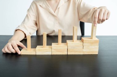 Ahşap blok oyunu oynayan iş kadınlarının elleri. Ticari büyüme ve başarı için yönetim riski ve strateji planlarını kabul et.