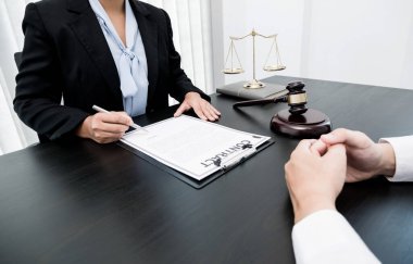 Bir kadın avukat ya da yargıç müvekkillerine adalet ve kovuşturma konusunda danışmanlık yapıyor. Teraziler, yargıç tokmağı, yasal belgeler, hukuk hizmetleri kavramı..