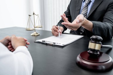 Bir erkek avukat ya da bir yargıç müvekkillerine yargı adaleti ve kovuşturma hakkında ölçekli danışmanlık yapıyor..