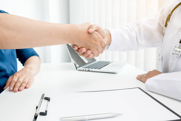 Doctors and patients shake hands after the patient has finished treatment. Medical concepts and good health.