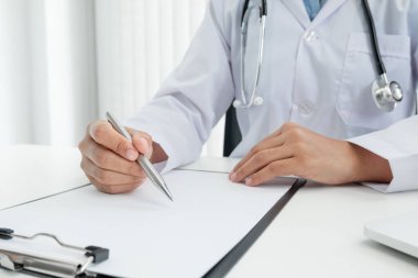 Kadın doktor oturdu ve hastanın geçmişini kontrol etti ve hasta bilgilerini kaydetmek için bir dizüstü bilgisayar kullandı. Tıbbi kavramlar ve ilgi alanları.
