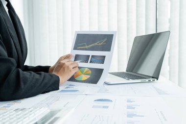 Erkek bir iş kadınının elleri, ofisteki bakiyeleri özetlemek amacıyla mali bir grafikte yıllık gelir ve giderleri analiz ediyor ve hesaplıyor..