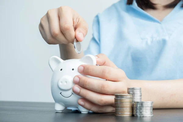 Women's hands are putting coins in the piggy bank Saving money with coins Step into a business that is growing to be successful and save for retirement ideas.