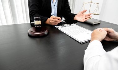Bir kadın avukat ya da yargıç müvekkillerine adalet ve kovuşturma konusunda danışmanlık yapıyor. Teraziler, yargıç tokmağı, yasal belgeler, hukuk hizmetleri kavramı..