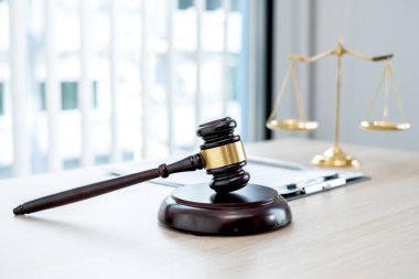 Yargıcın hukuk bürosundaki tokmağında teraziler, adalet terazileri ve dava belgeleri var. Hukuk ve adalet kavramları.