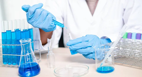 医学科学家在一个化学实验室将一个样本放入一个测试瓶中 用于分析病毒 科学研究概念 — 图库照片