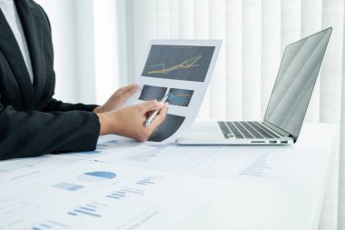 Erkek bir iş kadınının elleri, ofisteki bakiyeleri özetlemek amacıyla mali bir grafikte yıllık gelir ve giderleri analiz ediyor ve hesaplıyor..